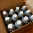 Load image into Gallery viewer, Cardboard box containing 12 plastic bottles of Neem oil with white caps
