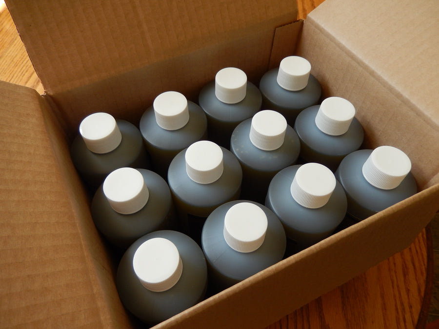Cardboard box containing 12 plastic bottles of Neem oil with white caps